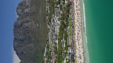 Pull-back-vertical-aerial-view-of-Camps-Bay-Beach-in-Cape-Town,-South-Africa