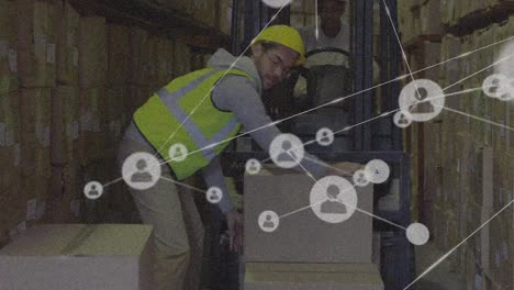 animación de iconos conectados con líneas sobre trabajador caucásico colocando cajas en carretillas elevadoras en el almacén.