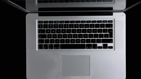 a man working on a laptop online from his home. top down view.