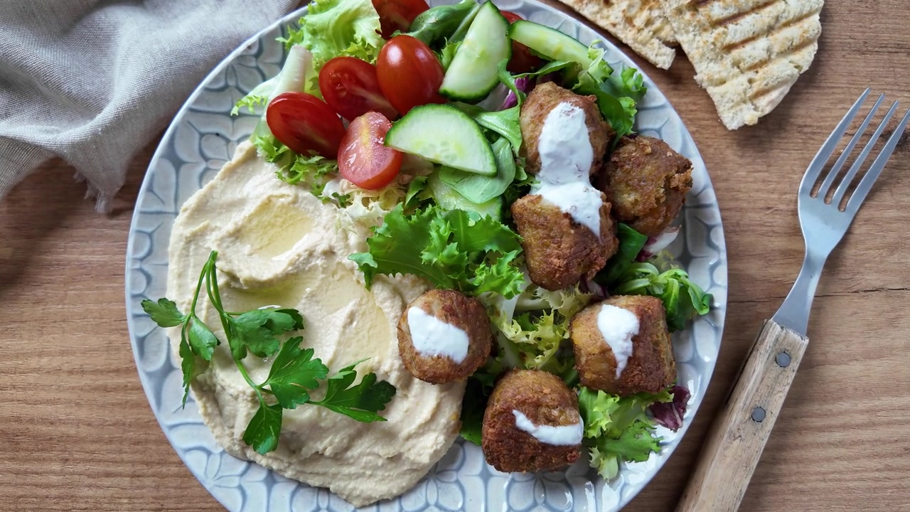 Falafel tradizionale servito con hummus e insalata fresca.