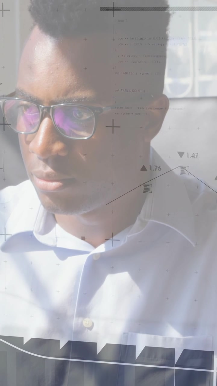 Vertical video: Man typing on keys starting business charts, pausing gaze left while checking data