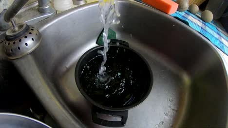 slow motion - flowing water from a sink faucet in the kitchen