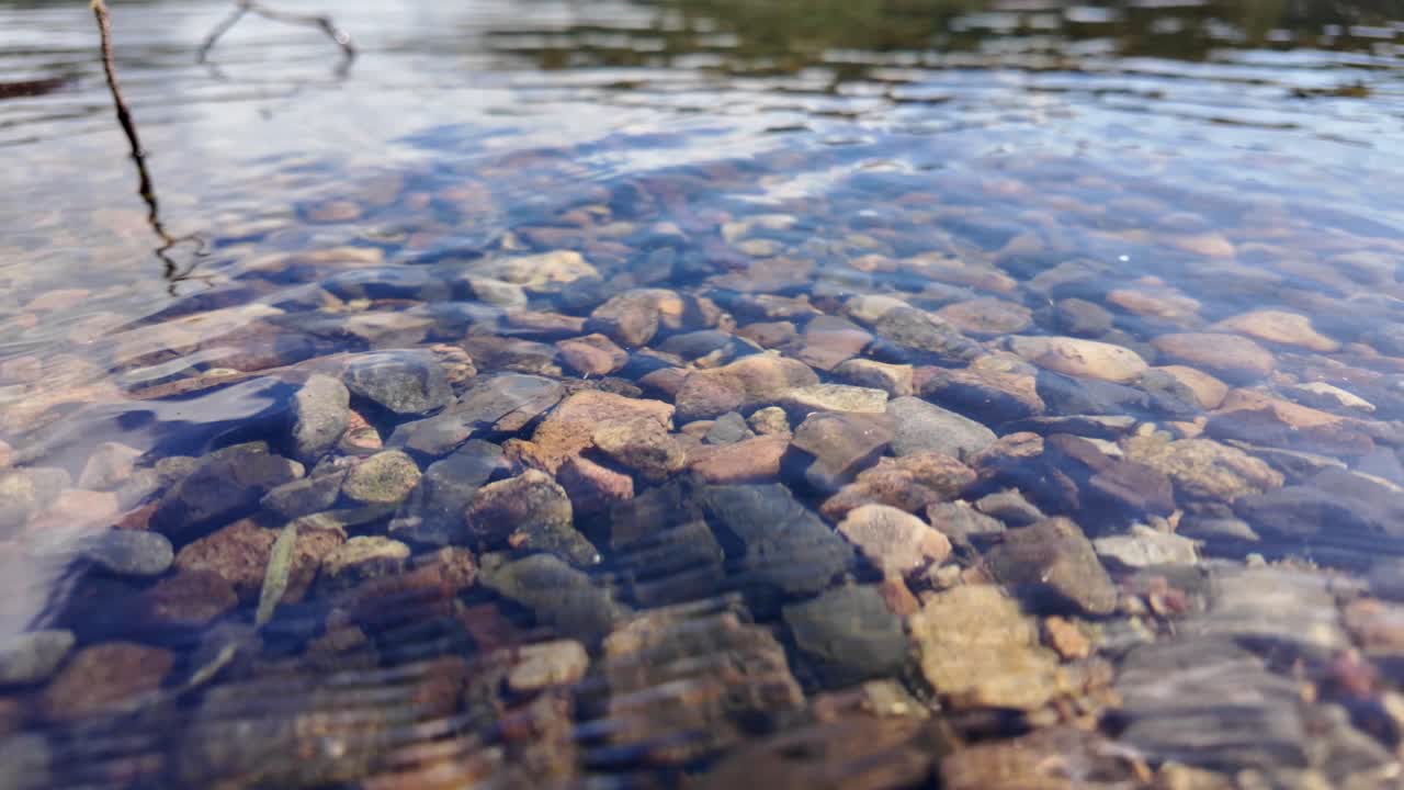 Clear Water Over Stones, Serene Shoreline with Gentle Ripples