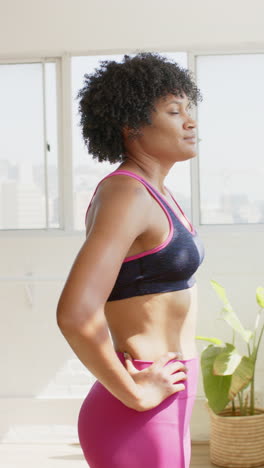 vertical video: strong and fit woman in yoga studio wearing sportswear, looking confident