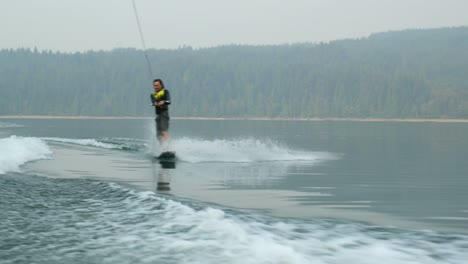 Vorderansicht-Eines-Kaukasischen-Jungen-Mannes,-Der-Tricks-Auf-Dem-Wakeboard-Im-Stadtfluss-Macht,-4k