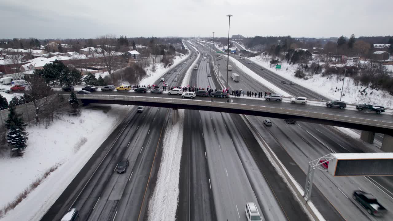 토론토 외곽의 고속도로 교량 고가도로 가장자리를 따라 서 있는 캐나다 자유 집회 시위자들의 시네마틱 드론 샷