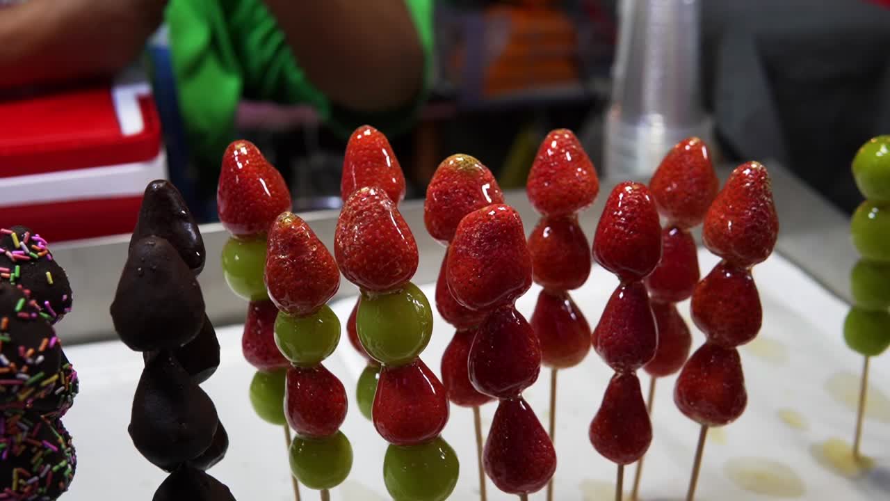 Jordbær-Tanghulu, godteribelagte frukter på spyd, populær dessert og gatemat i Asia