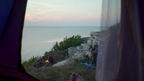 looking out from tent at popular tourist camping spot location sweden visit tourism german camper hiking driving caravan to fireplace having good time sunset view over night cozy hipster lazy days bbq