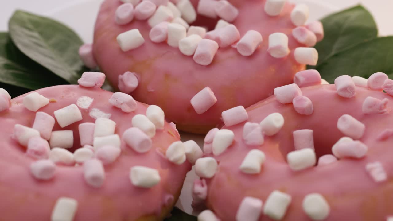 달한 아이싱으로 인 맛있는 둥근 도의 클로즈업은 밝은 배경에서 회전합니다. 달한 디저트 분홍색 도