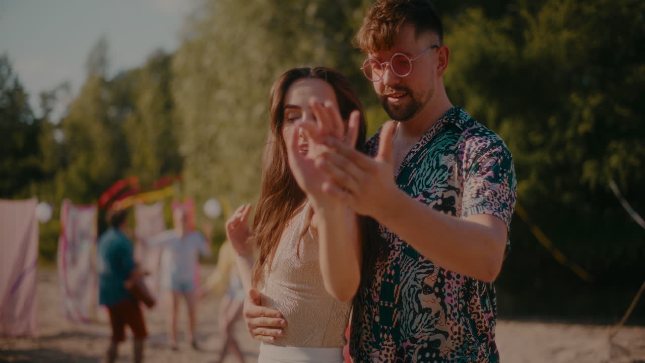 Young woman and man dancing bachata at beach
