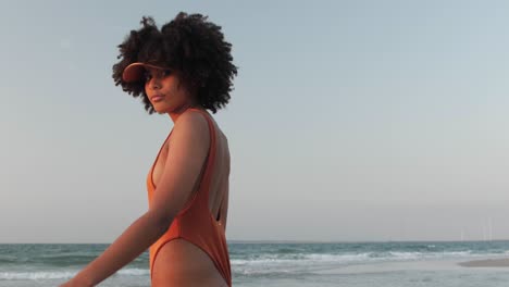 young girl with curly afro hair walking on a beach
