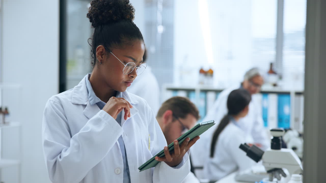 Giovane scienziata concentrata che utilizza un tablet in laboratorio