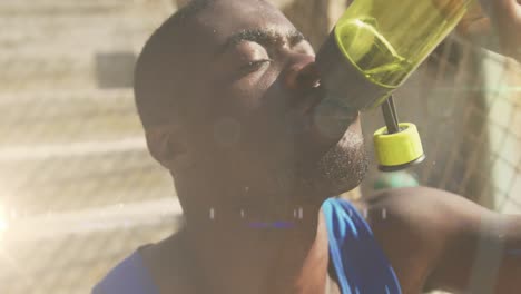 Animation-of-glowing-lights-over-an-exercising-african-american-man-drinking-water