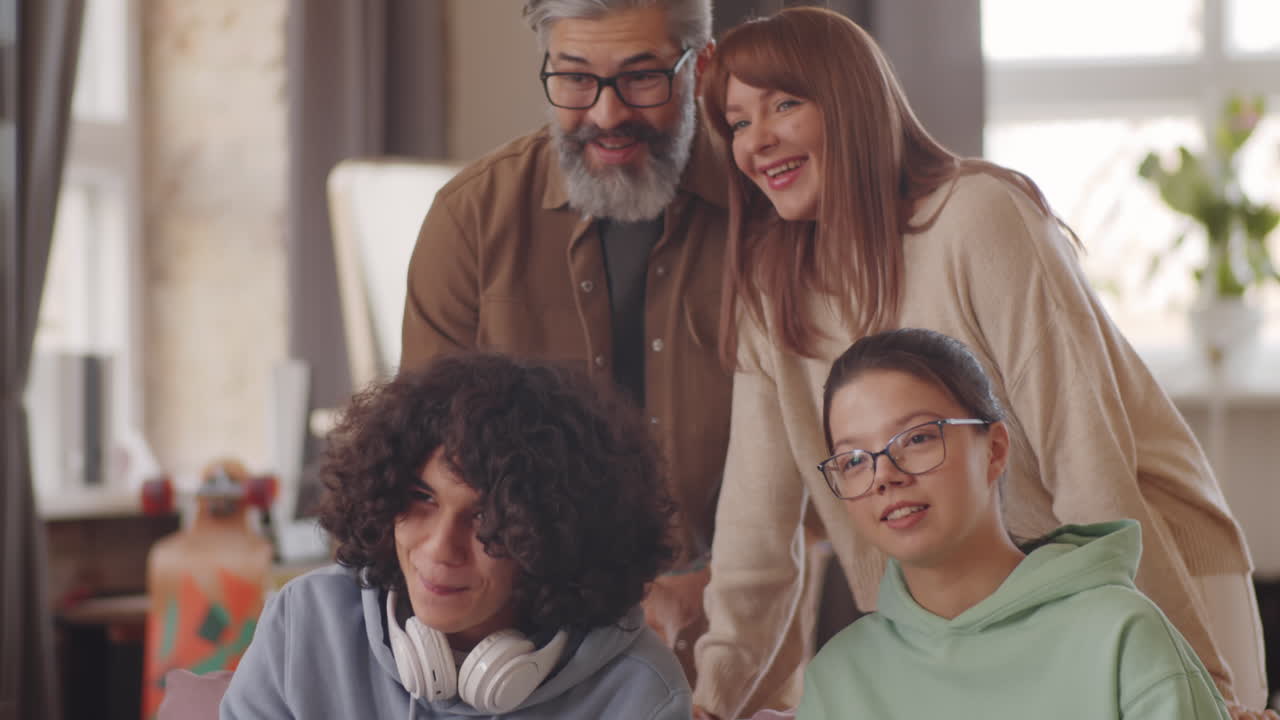 adolescentes jugando a juegos de consola con el apoyo de padres alegres