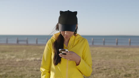 portrait of teenage girl smiling posing taking selfie photo using smartphone at seaside park