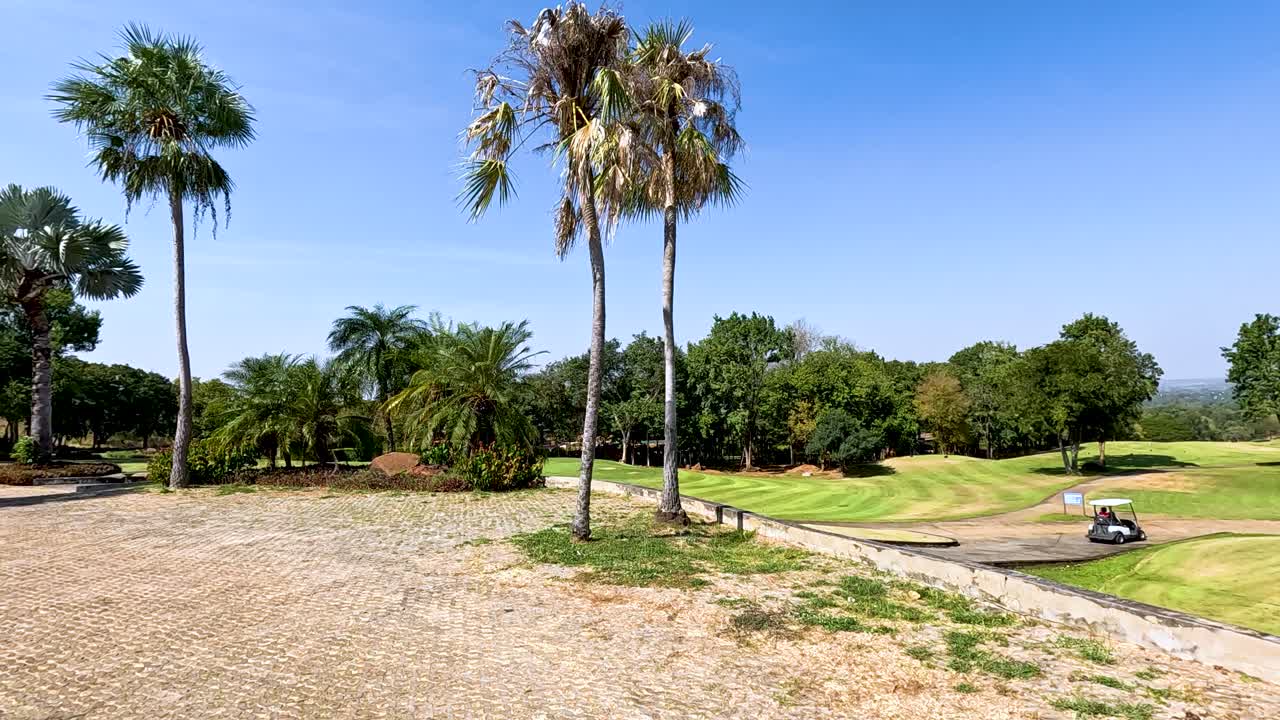 un carro de golf se mueve a través de un paisaje exuberante