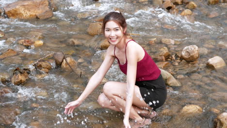미녀는 여름 방학 시간에 강에서 물이 튀는 놀이로 편안하고 쾌활합니다.