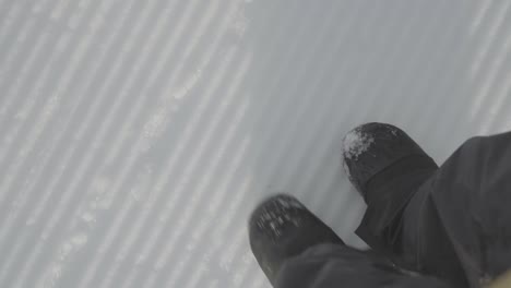 walking on the snow covered prepared slope in ski resort. snowboard boots walking.