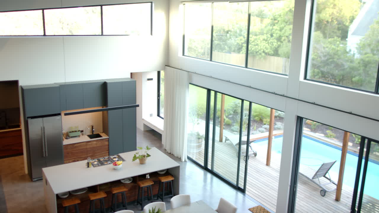 Modern home with large windows overlooking pool and garden, bright and airy space, copy space