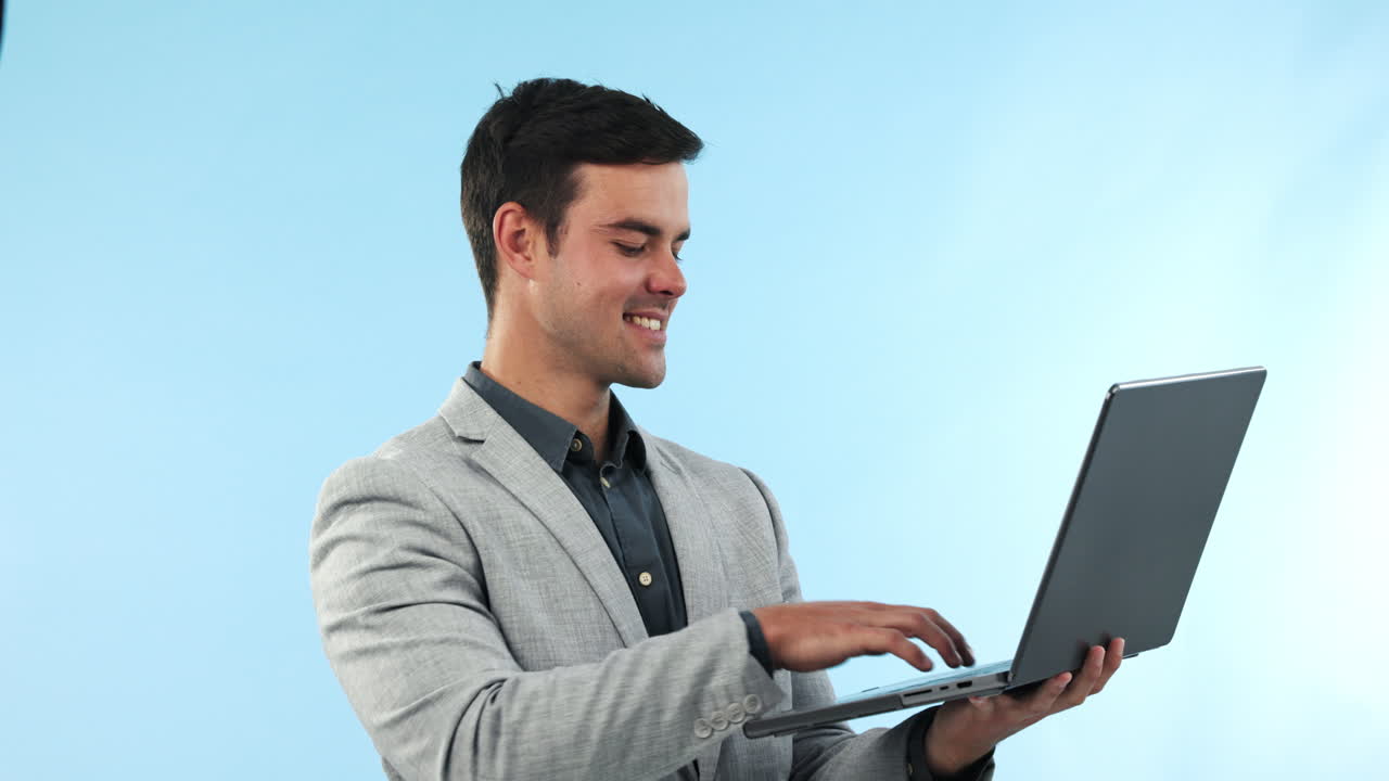 portátil, feliz y joven hombre de negocios en el estudio