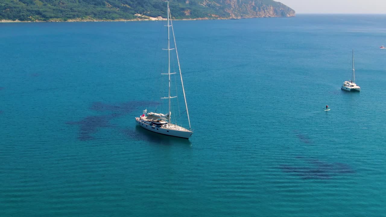 playa de agios georgios con dos barcos en verano corfu grecia