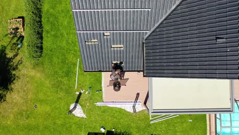 men installing solar panels on roof - aerial drone shot