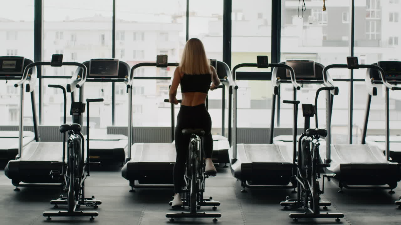 Woman Working Out on Exercise Bike in Gym