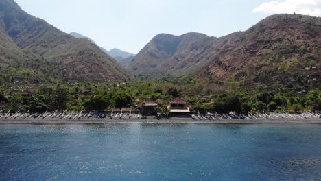 amed beach and mountains in bali with fishing boats along the beach