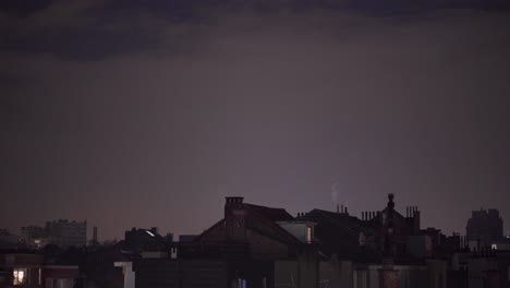 Toma-Panorámica-Cinematográfica-De-Personas-En-La-Terraza-De-La-Azotea-Caminando-De-Regreso-Al-Interior-Durante-Una-Noche-Fría-En-La-Ciudad-Europea