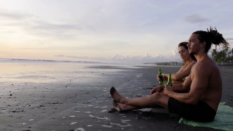 pareja joven sentada en la arena