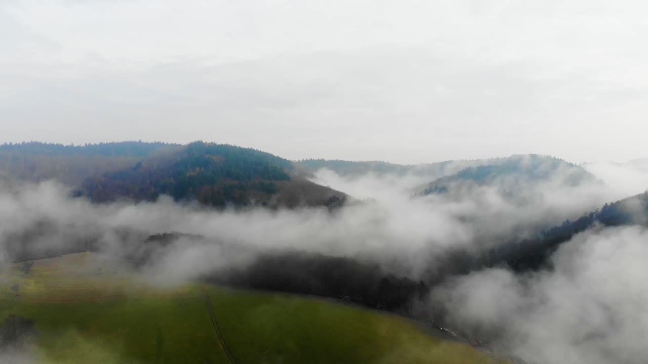 Drone view flying over the green field in the Baden-W&uuml;rttemberg, Odenwald Nature park on a foggy day, Germany