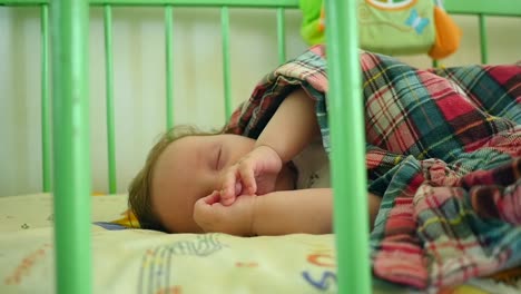 sleeping baby covered in the crib