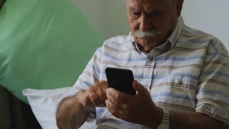 Senior-man-in-social-distancing-using-smartphone