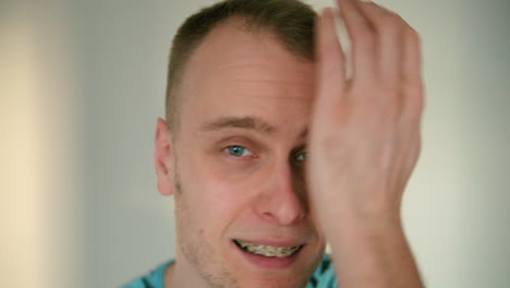 Close-up-of-happy-young-man-fixing-his-hair-in-slow-motion