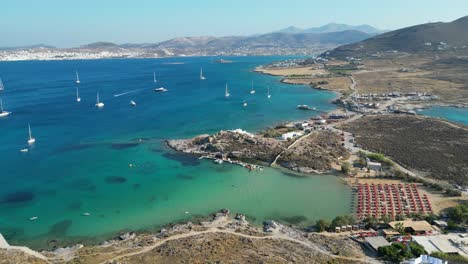 aerial footage of turquoise waters and a small beach club on the island of paros, one of the many cyclades islands in the aegean sea