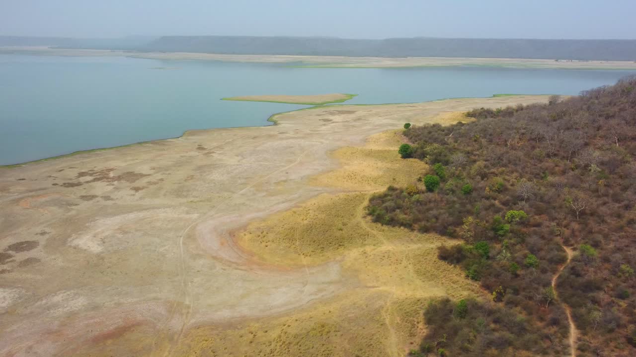 Aerial drone shot of a dried up lake reservoir along forest at harsi dam in gwalior india