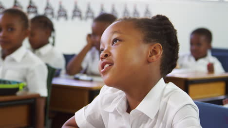 schoolgirl listening in elementary school class, close up