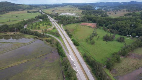 Vehicles-Navigating-On-Pacific-Motorway-Through-Fields-In-Tanglewood,-NSW,-Australia