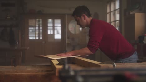 a carpenter sanding plywood in his workshop