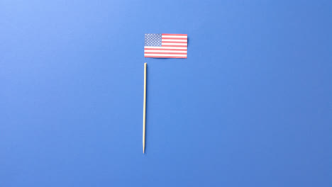 national flag of usa and stick lying on blue background with copy space