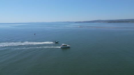 Ein-Schnellboot-Passiert-Eine-Kleine-Yacht-Am-Strand-Von-Exmouth-In-Devon-Mit-Torbay-Im-Hintergrund