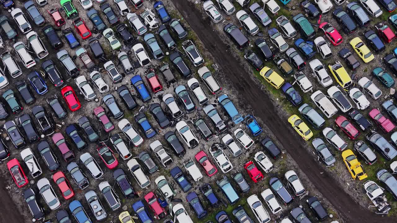 Biler parkeret på en stor autoophugningsplads i dagslys