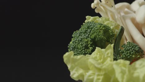 cerca de una olla de ingredientes de shabu girando en el fondo negro