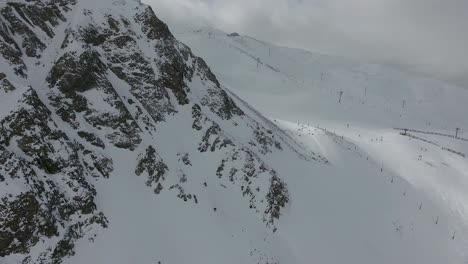 Un-Dron-En-Reversa-Disparó-Sobre-Practicantes-De-Snowboard-Fuera-De-Pista,-Subiendo-Por-El-Terreno-Extremo-Del-&quot;muro-Este&quot;,-Que-Se-Cierne-Sobre-La-Estación-De-Esquí-De-Arapahoe-Basin,-En-Las-Montañas-Rocosas-De-Colorado.