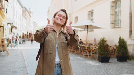 happy woman showing thumbs up like sign positive something good positive feedback on city street