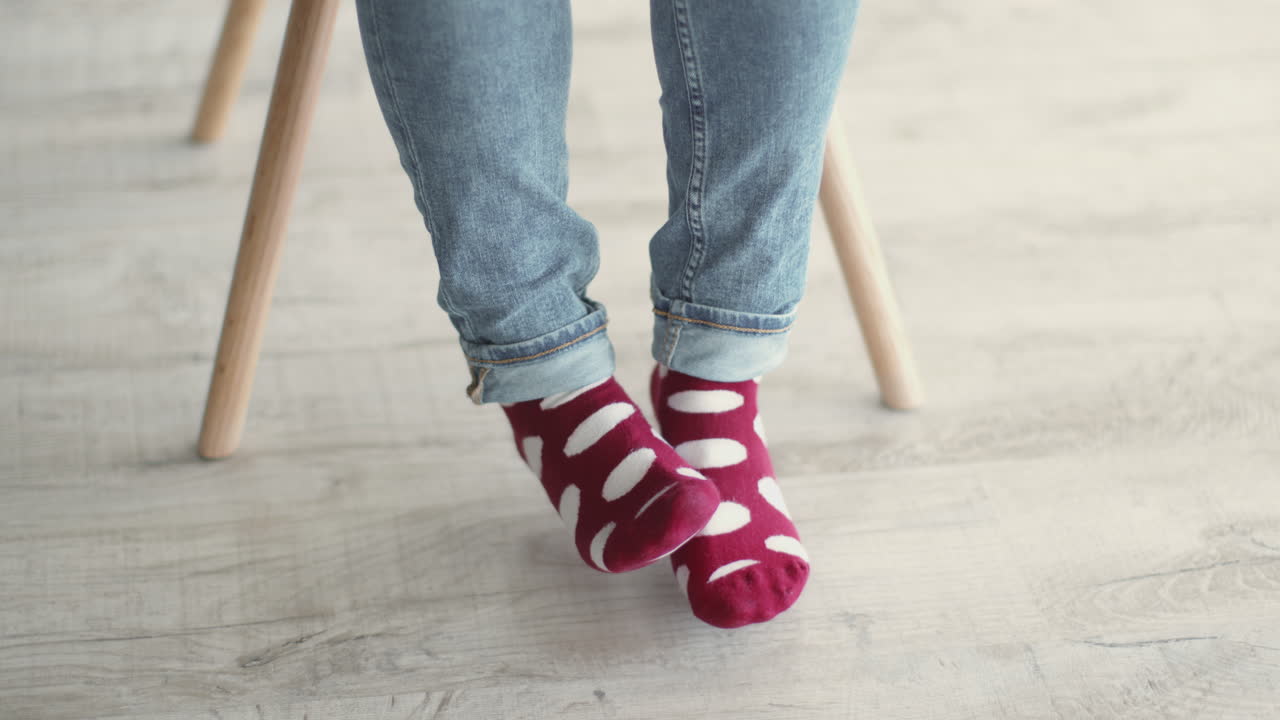 persona con calcetines rojos con puntos y vaqueros azules