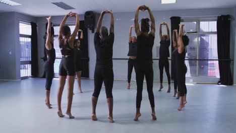 multi-ethnic group of fit male and female modern dancers practicing a dance routine