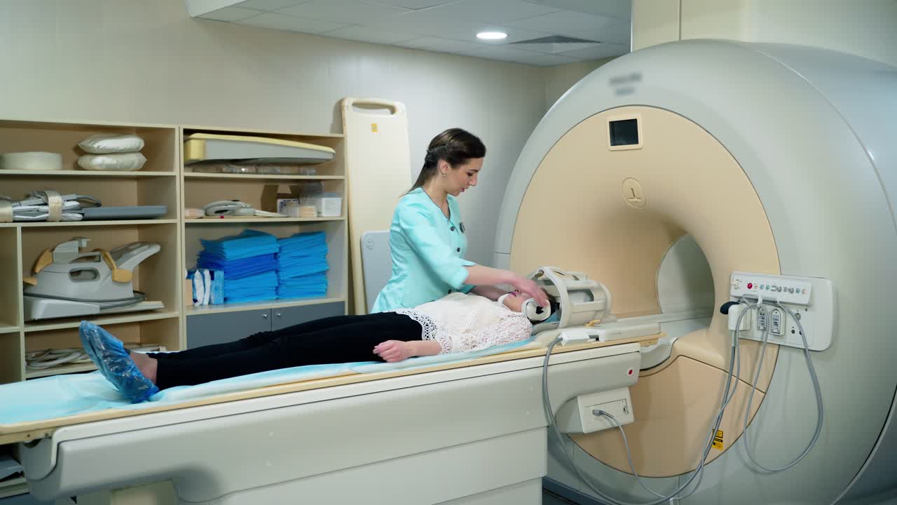 Medical scanning equipment and a female patient. Doctor preparing patient before the mri procedure. Woman lays in magnetic resonance image device.
