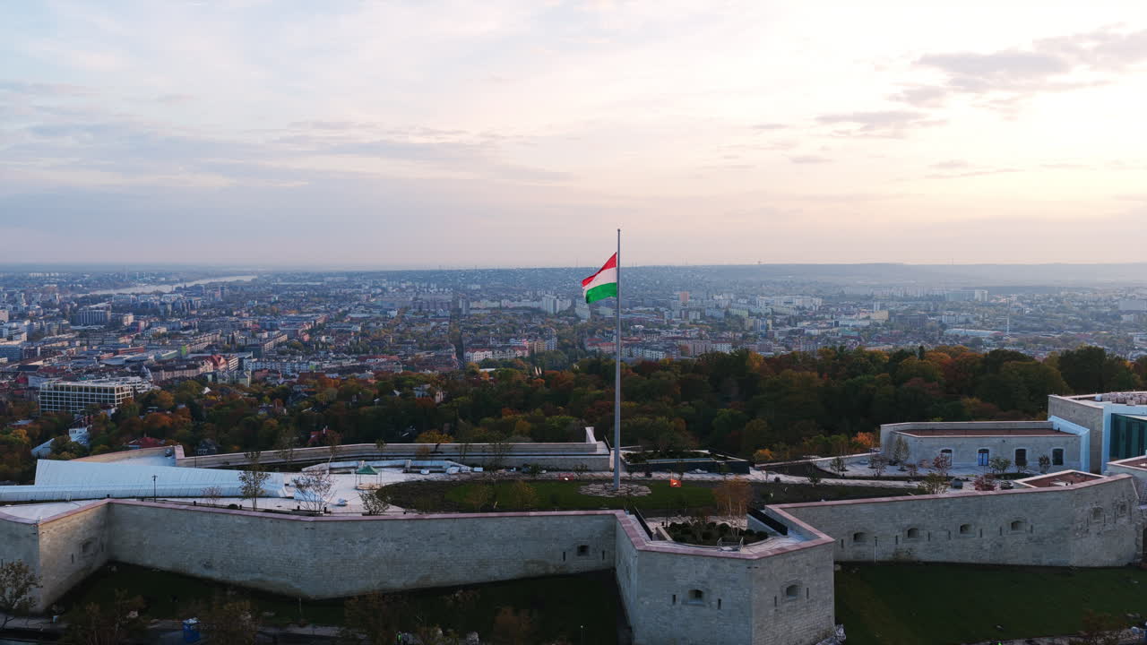 La cittadella sulla collina Gellért con la statua della Libertà e la bandiera ungherese che domina Budapest al tramonto