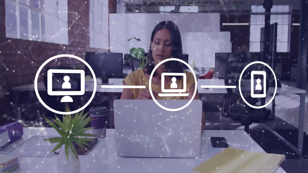 animación de una red de iconos digitales contra una mujer biracial pensativa que usa una computadora portátil en la oficina